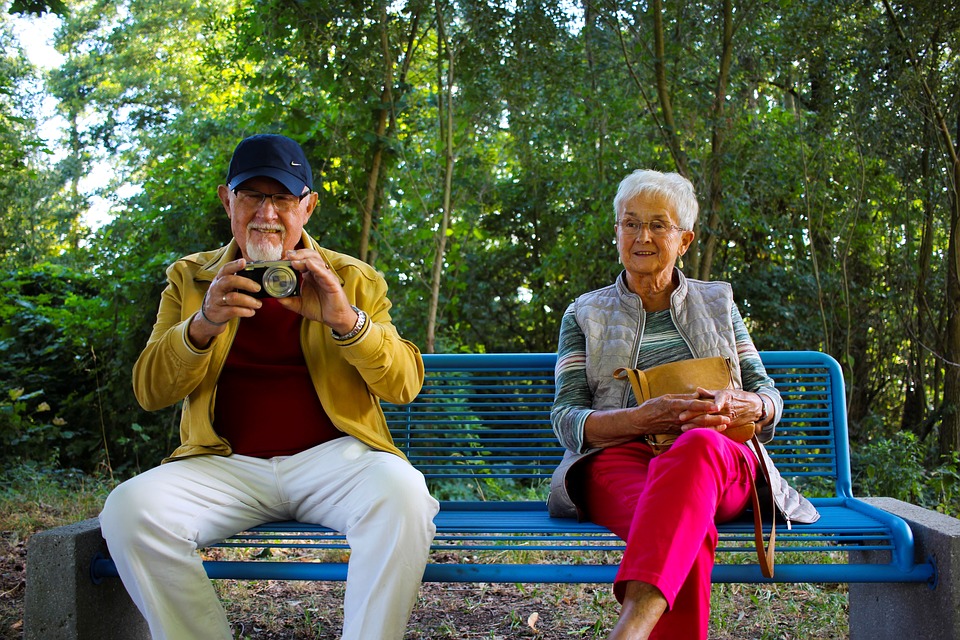 Zwei Rentner sitzen auf einer Bank und genießen ihre Zeit.
