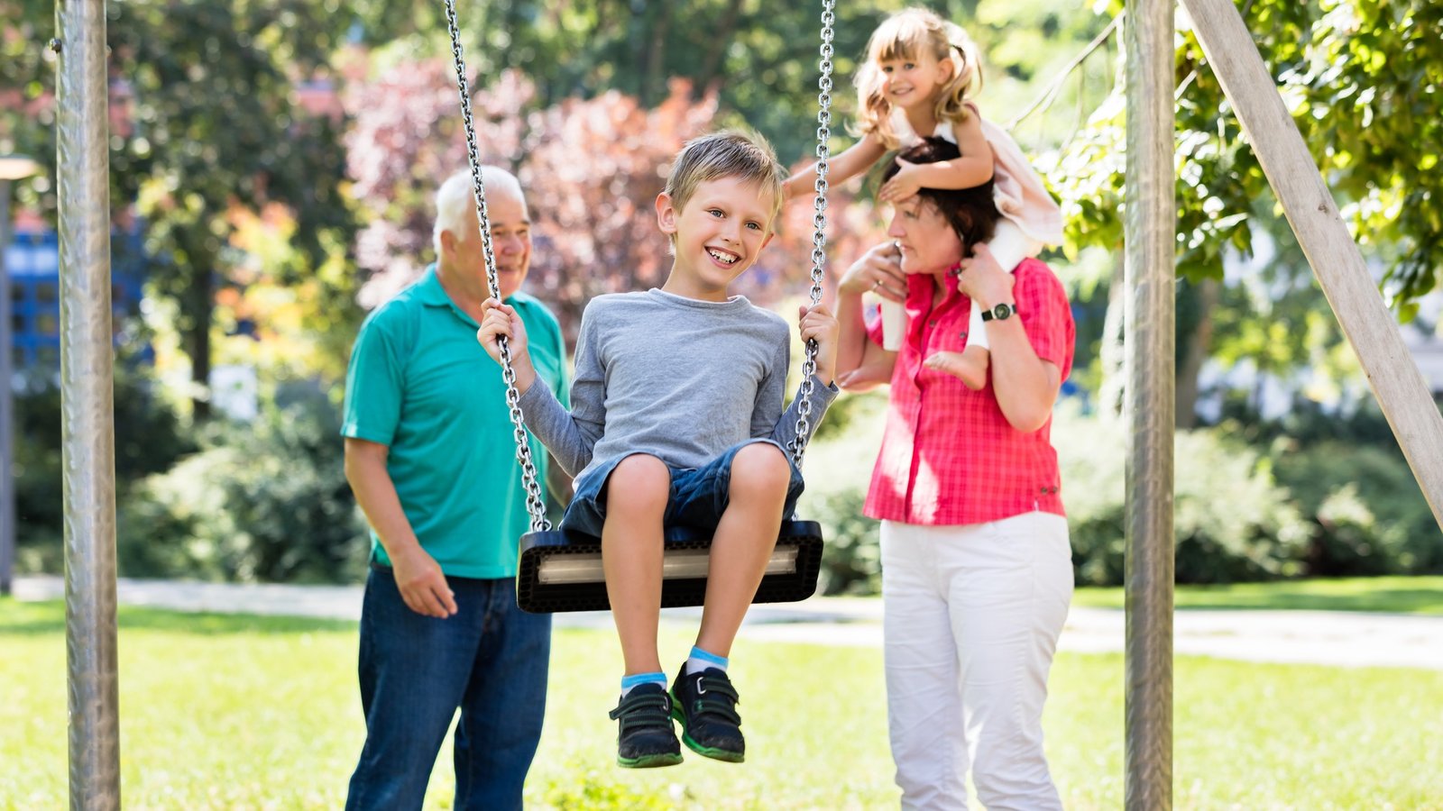 Großeltern mit ihren Enkelkindern auf dem Spielplatz