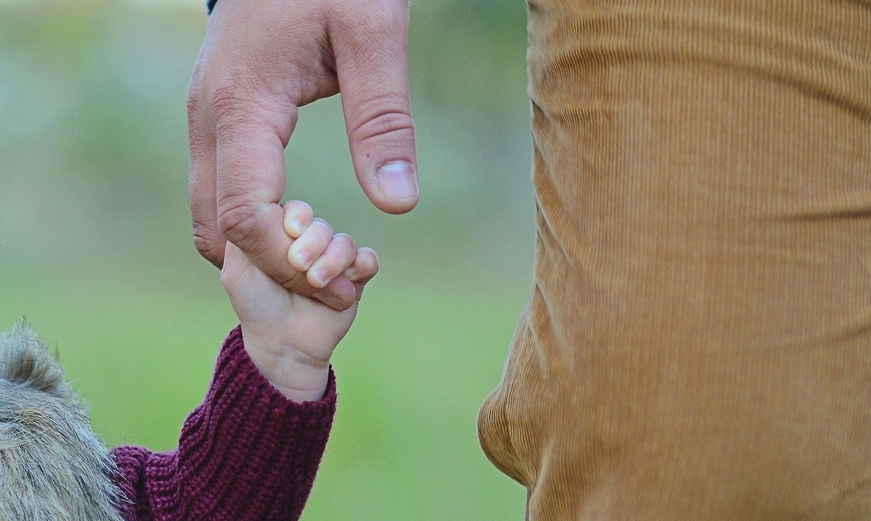 Ein Vater hält die Hand seines Kindes