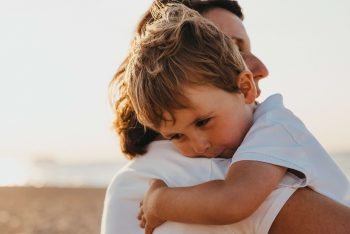 Ein kleiner Junge liegt in den Armen seiner Mutter