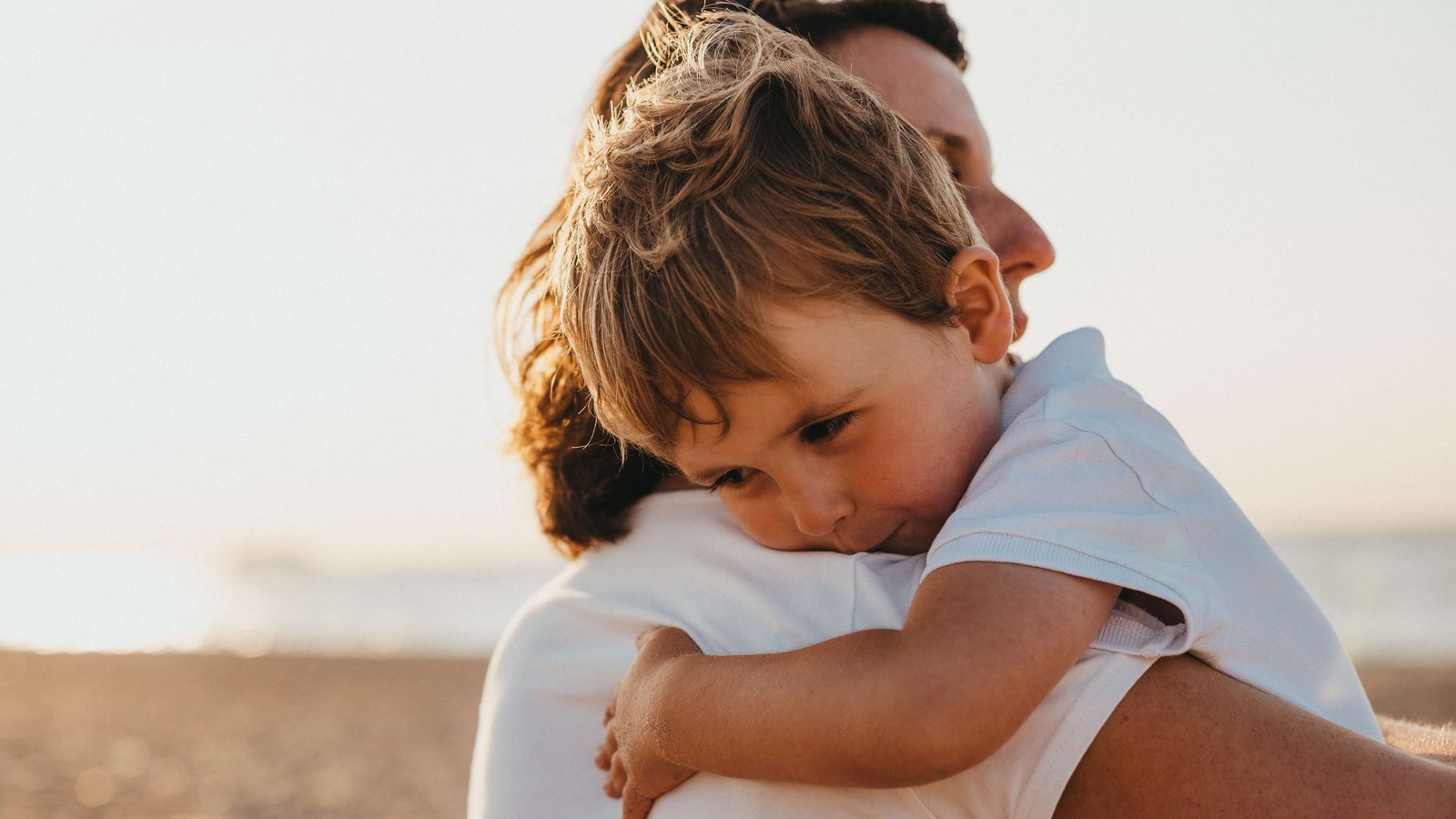 Ein kleiner Junge liegt in den Armen seiner Mutter