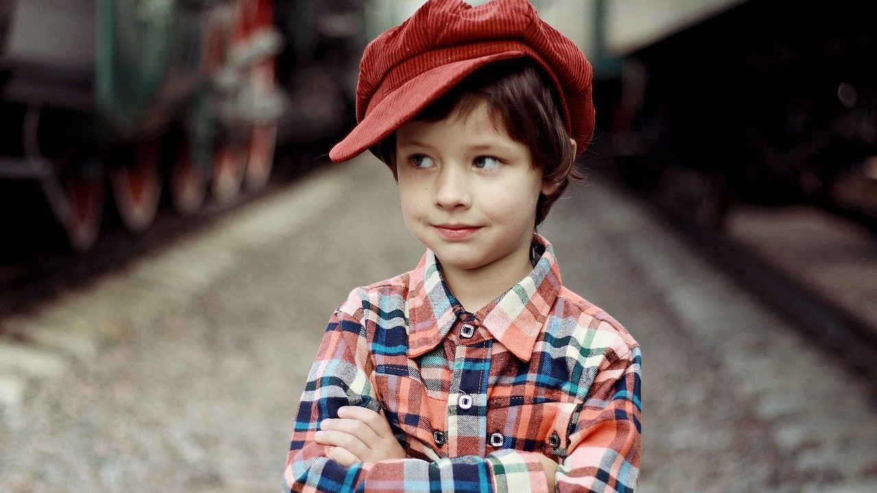 Ein Junge mit roter Mütze schaut zur Seite