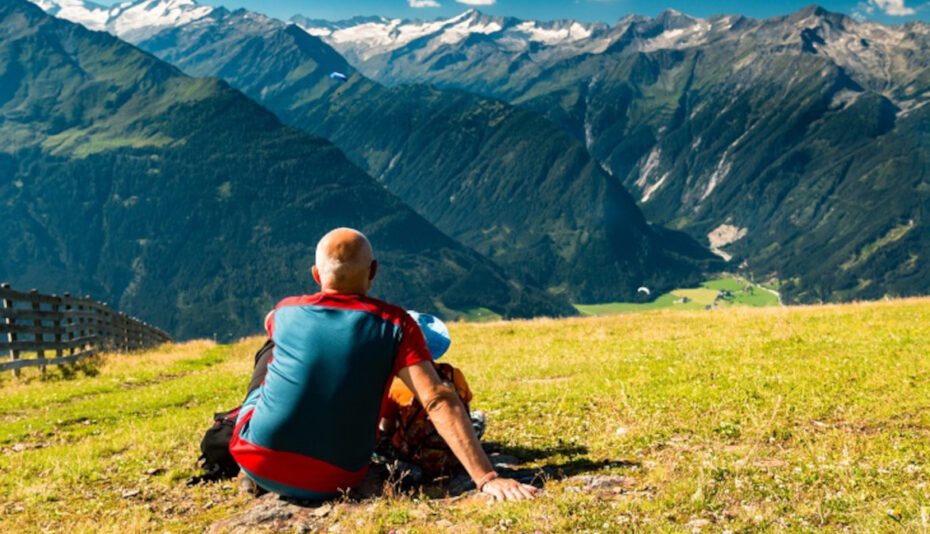 daddy with child looking at mountain peaks and paragliders in au